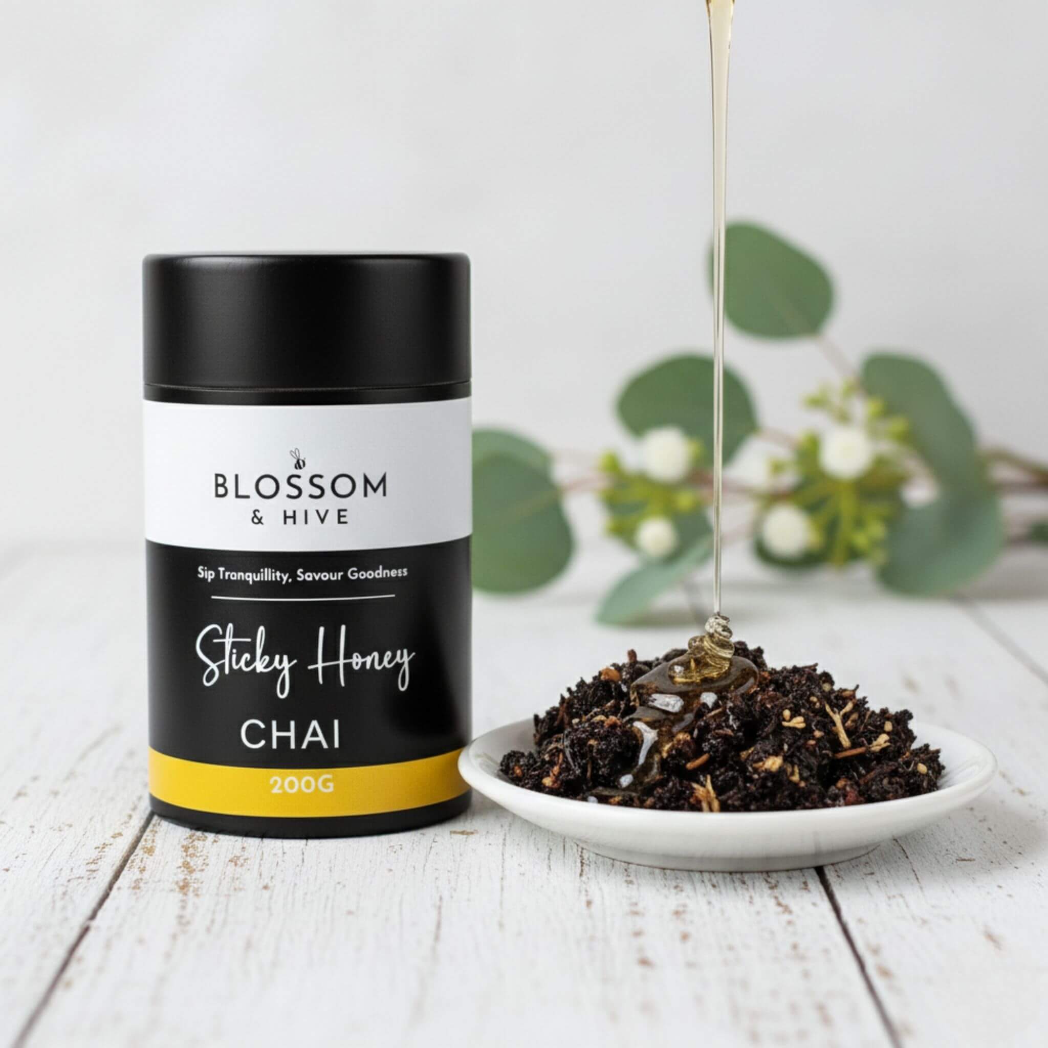 Blossom & Hive Sticky Honey Chai packaging with a bowl of chai on a wooden surface.