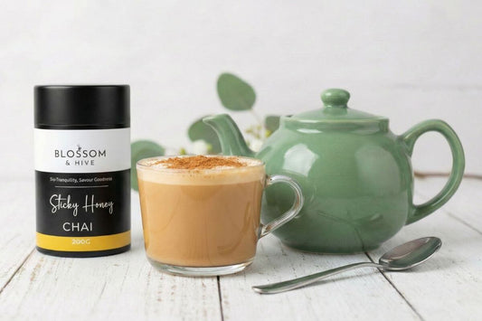 Blossom and Hive Sticky chai with a green ceramic teapot and a glass cup filled with chai and a spoon