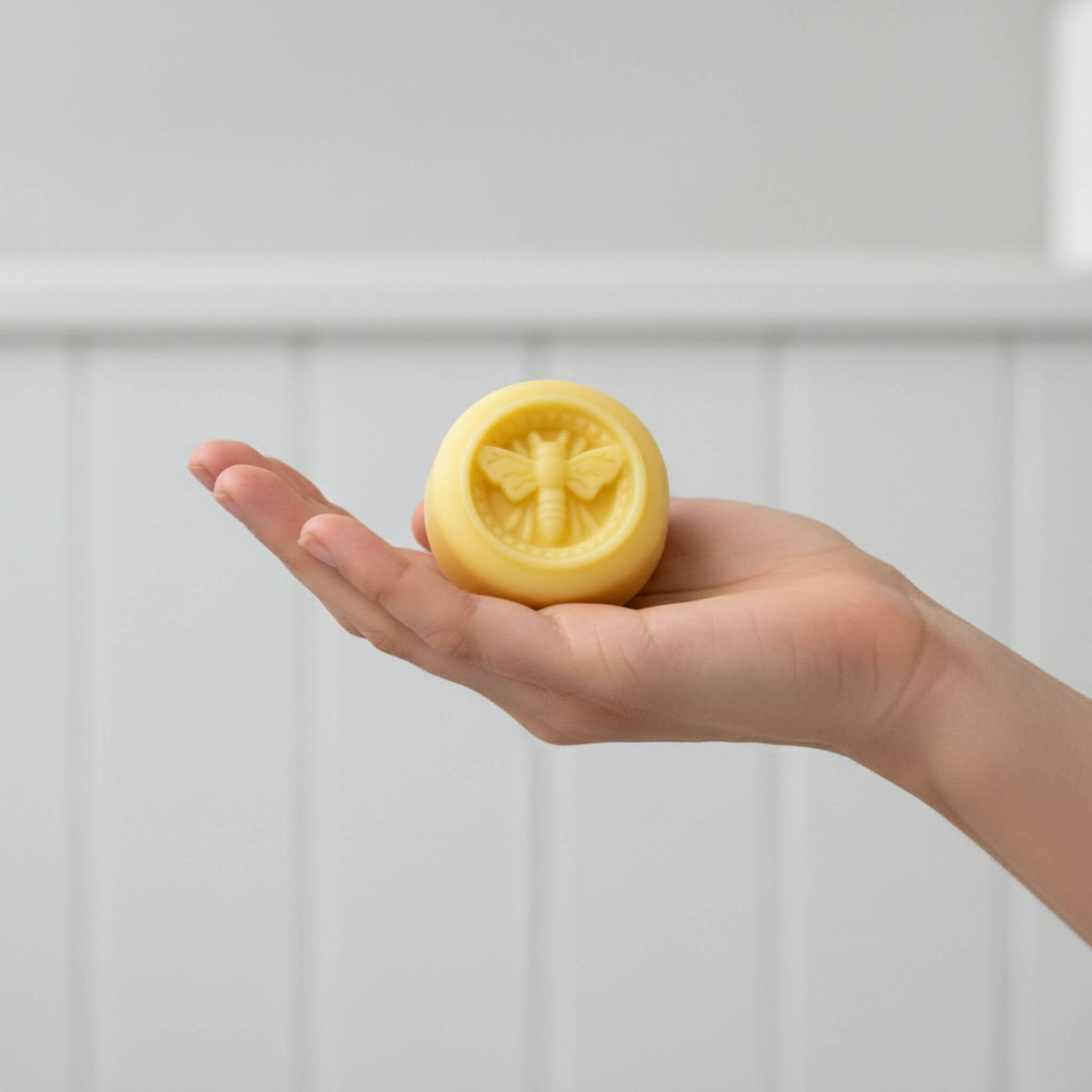 Blossom & Hive Honey and Mint lotion bar held in a woman's hand

