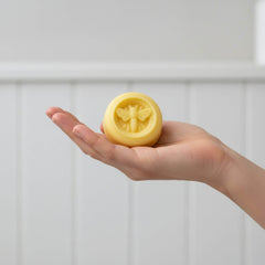 Blossom & Hive Honey and Mint lotion bar held in a woman's hand
