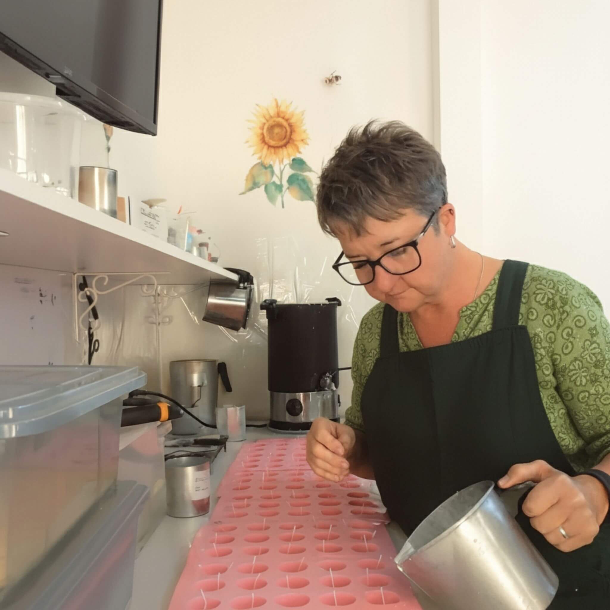 Sue Murphy - founder of Blossom & Hive in her studio in regional NSW, hand-pouring beeswax tealights.