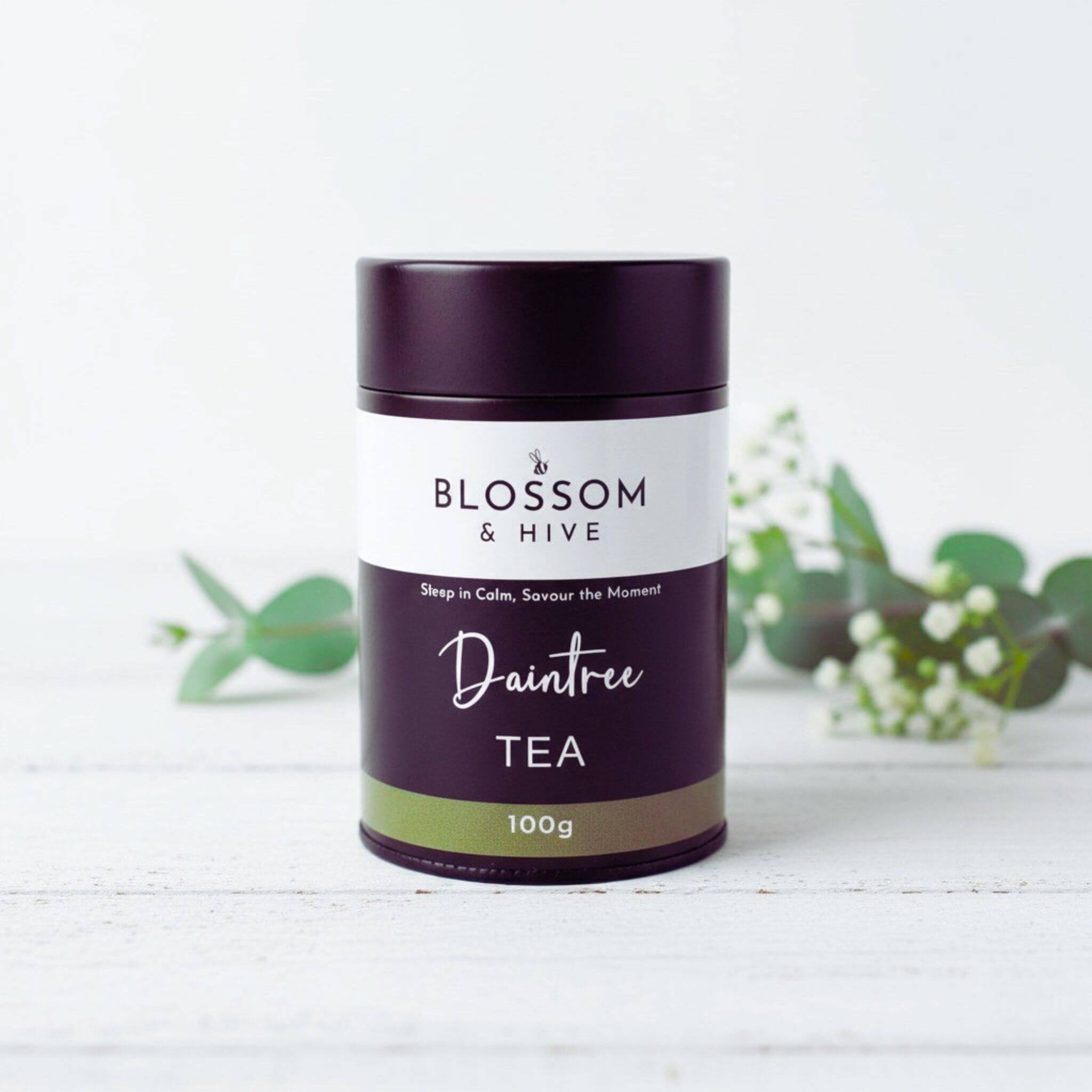 Tea canister labeled 'Blossom & Hive Daintree Tea' on a white background with green leaves.
