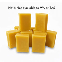 Yellow rectangular bars of beeswax stacked on a white background with text indicating availability restrictions.